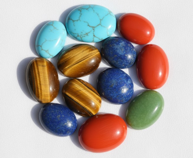 Polished cabochon gemstones in various colors and shapes